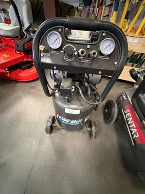 un petit compresseur d'air posé par terre dans le garage