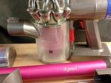 une photo d'un aspirateur rose et argent posé sur une table