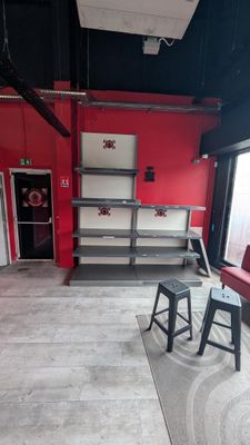 a room with a red couch and a black chair