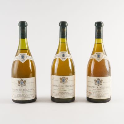 trois bouteilles de vin posées les unes à côté des autres sur une surface blanche