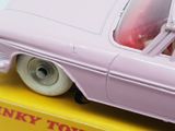 a pink toy car sitting on top of a yellow box