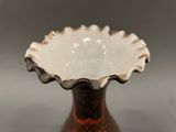 a brown and white vase sitting on a table