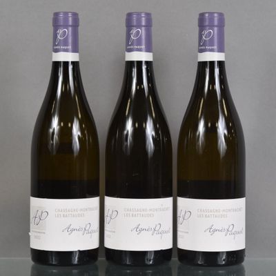 three bottles of wine are lined up on a glass table