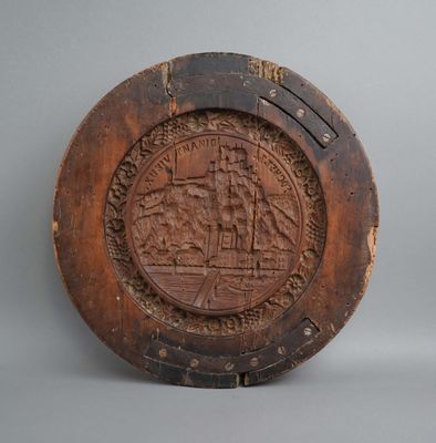 an old wooden plate with a picture of a ship on it