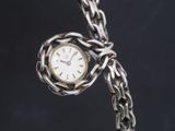 une horloge en argent attachée à une chaîne en argent