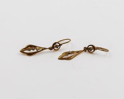 une paire de boucles d'oreilles en or sur fond blanc