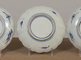 three plates with blue and white designs on them sitting on a table