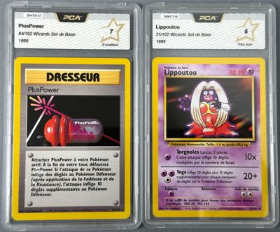two pokemon cards are shown in plastic cases on a table