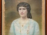 portrait d'une femme en robe bleue portant un collier en or
