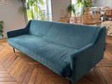 une photo d'un salon avec un canapé bleu