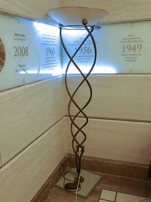 a lamp that is on a stand in the corner of a room