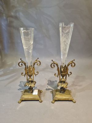pair of gold plated candlesticks with glass vases on stands