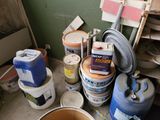 many buckets of paint and cans of paint on the floor