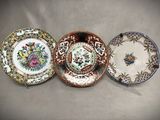 three plates with different designs on them sitting on a table
