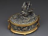 une boîte en argent et en or ornée d'un oiseau
