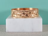 a close up of a gold ring on a marble block