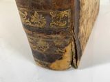 an old book sitting on top of a white table next to a white wall