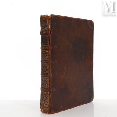 un vieux livre posé sur une table blanche à côté d'un mur blanc