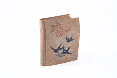 un livre marron orné d'oiseaux, posé sur une surface blanche