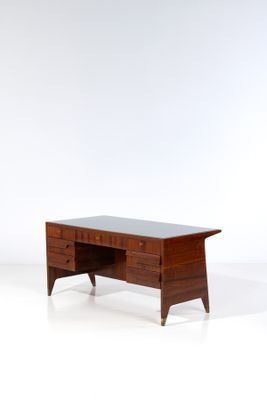 une photo d'un bureau avec un plateau en verre et des pieds en bois