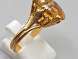 a close up of a gold ring with a large citrine stone