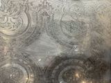 a silver tray with a pattern on it sitting on a table