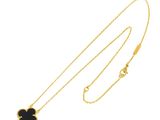 a gold necklace with a black flower on it