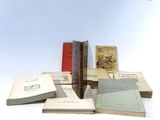 several books are stacked on top of each other on a white surface