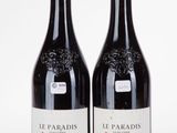 two bottles of wine sitting next to each other on a white surface
