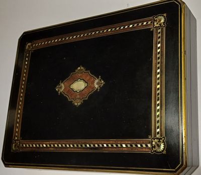 une boîte noire et dorée sur laquelle figure une image