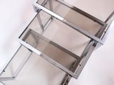 a metal shelf with three glass shelves on it