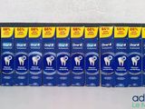 several boxes of toothpaste are lined up on a shelf