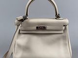 a white leather handbag on a grey background