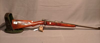 un vieux fusil avec un canon en bois sur un support sur fond blanc