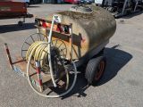un petit chariot muni d'un tuyau, garé sur un parking