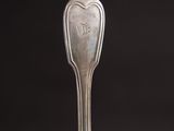 silver spoon with a heart shaped handle on a black background