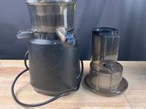 a juicer that is sitting on a table next to a blender