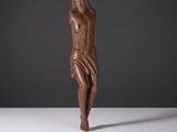 une sculpture en bois représentant une femme se tenant la tête entre les mains