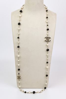 un collier avec un mannequin blanc orné de perles noires et blanches