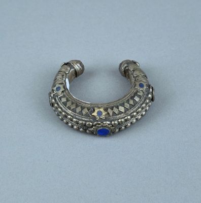 un gros plan d'une bague en argent sertie d'une pierre bleue