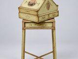 une vieille boîte en bois munie d'une poignée, posée sur un support