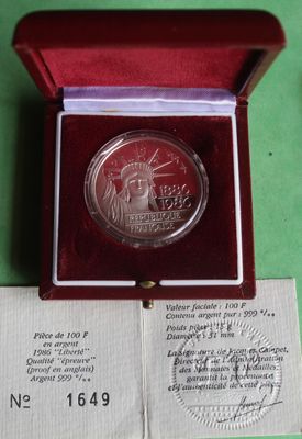 a silver coin in a red box on a green surface