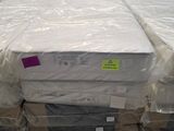 de nombreux cartons de matelas posés à même le sol dans un entrepôt