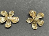 pair of gold tone flower earrings on a black surface