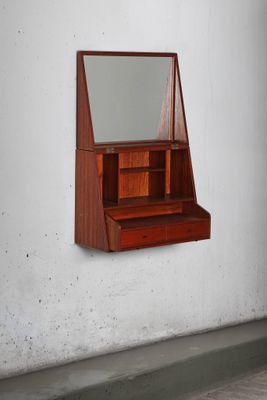 une étagère en bois sur laquelle est posé un miroir, dans une pièce