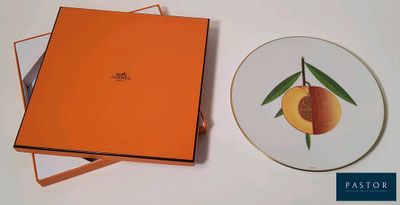 une boîte orange avec une assiette, et une assiette sur laquelle se trouve une pêche