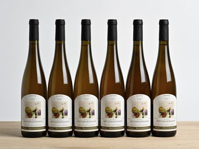 six bouteilles de vin sont alignées sur une table en bois