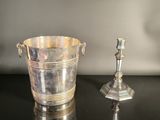 a silver ice bucket and a candle holder on a table
