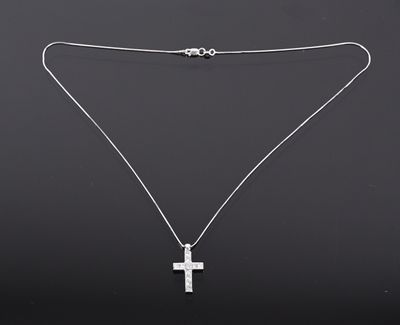 un collier avec une croix suspendue à une chaîne, sur fond noir