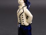 a figurine of a man with a hat and blue pants